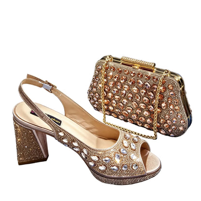 A pair of gold embellished slingback high-heeled sandals displayed with a matching gold rhinestone clutch bag on a draped blue velvet background.